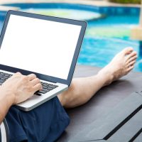 Screen mockup of laptop that a man is using in the pool on vacation - work anywhere and internet work concept